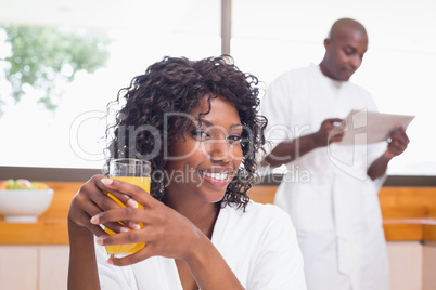 Pretty woman in bathrobe having juice