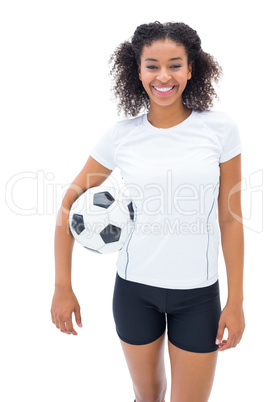 Pretty football fan in white holding ball smiling at camera Pretty football fan in white holding ball smiling at camera