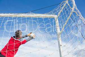 Goalkeeper in red making a save