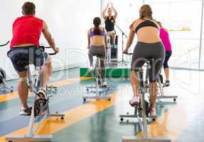 Spin class working out with motivational instructor