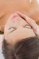 Attractive young woman receiving facial massage at spa center