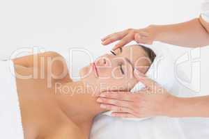 Attractive woman receiving facial massage at spa center