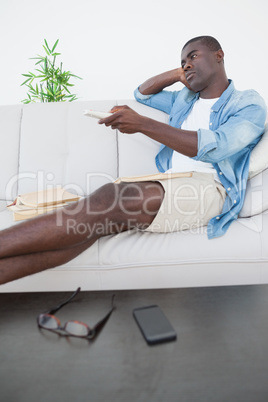 Casual man sitting on sofa watching tv