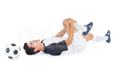 Football player in white lying injured