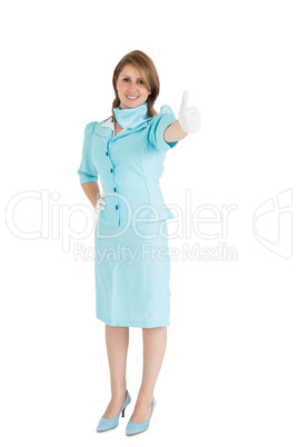Stewardess in blue uniform gesturing thumbs up