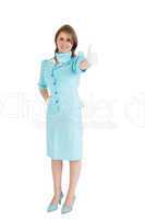 Stewardess in blue uniform gesturing thumbs up