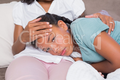 Sick daughter lying on mothers lap