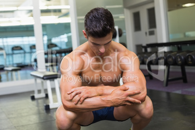 Shirtless muscular man posing in gym