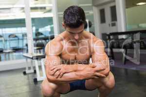 Shirtless muscular man posing in gym