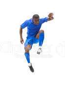Football player in blue kicking and jumping