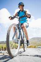 Fit man cycling on rocky terrain