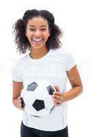 Pretty football fan in white holding ball smiling at camera