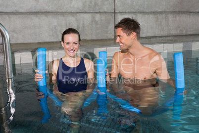 Happy couple holding foam rollers