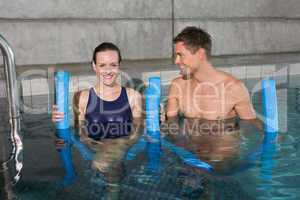 Happy couple holding foam rollers