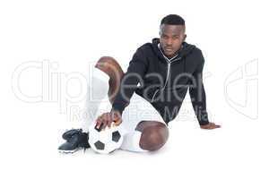 Football player sitting with ball