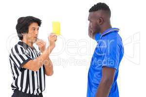 Referee showing yellow card to football player