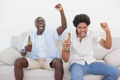 Football fans cheering holding beer bottles