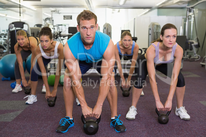 Muscular instructor leading kettlebell class