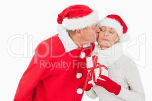 Festive couple smiling and holding gift