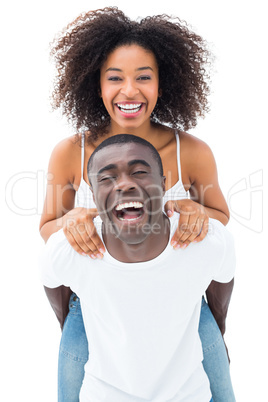 Casual man giving his smiling girlfriend a piggy back