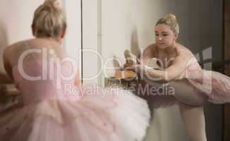 Beautiful ballerina warming up with the barre