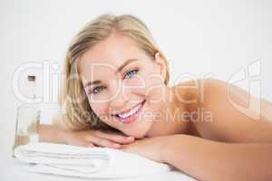 Beautiful blonde lying on massage table smiling at camera
