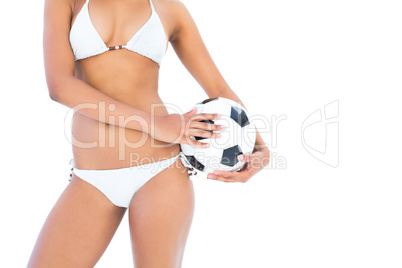 Fit girl in white bikini holding football