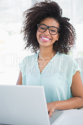 Happy hipster businesswoman working on laptop