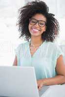 Happy hipster businesswoman working on laptop