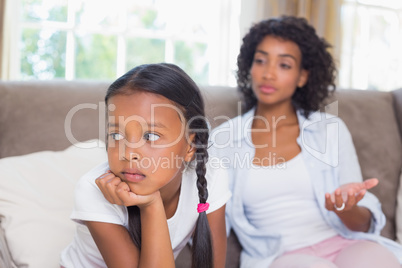 Pretty mother sitting on couch after an argument with daughter