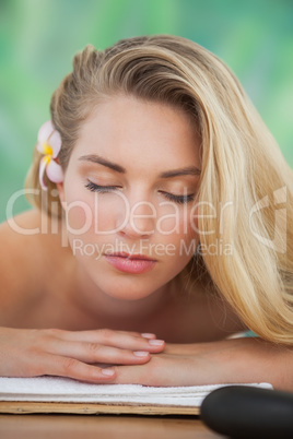 Peaceful blonde lying on towel with candle