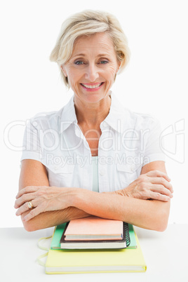 Happy mature student sitting with notebooks