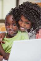 Mother and son using laptop at table