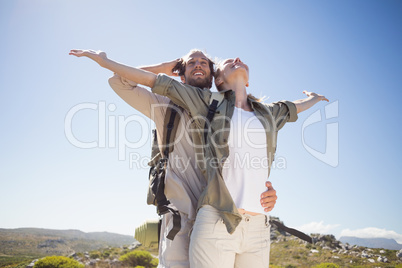 Hiking couple standing on mountain terrain admiring the view