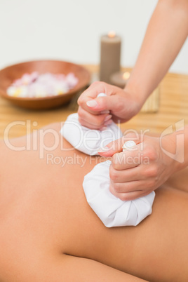 Woman enjoying a herbal compress massage