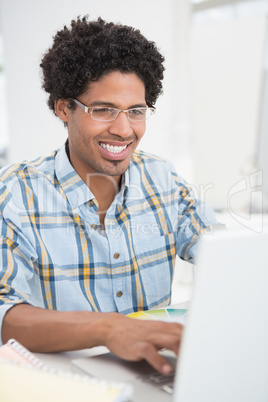 Focused young businessman working on laptop