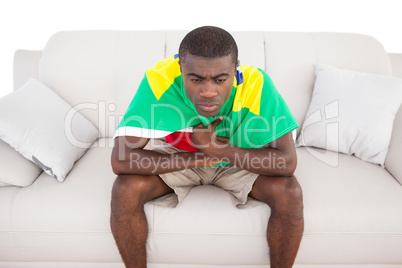 Upset brazilian football fan sitting on couch