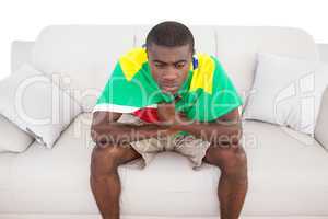 Upset brazilian football fan sitting on couch