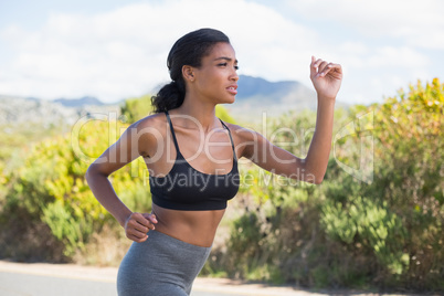 Fit woman running along the open road