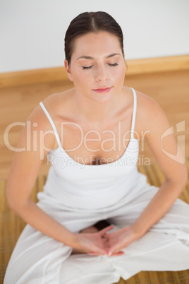 Woman sitting in lotus pose with eyes closed