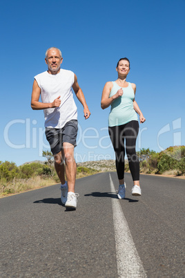 Fit couple running on the open road together