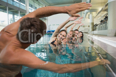 Female fitness class doing aqua aerobics with male instructor