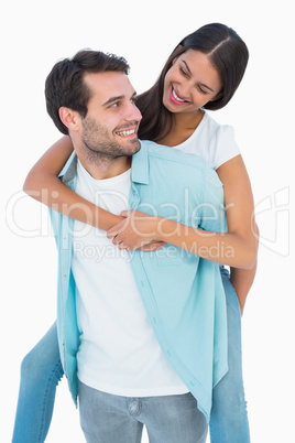 Happy casual man giving pretty girlfriend piggy back