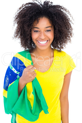 Pretty girl in yellow tshirt holding brazilian flag smiling at c