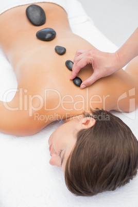 Beautiful woman receiving stone massage at spa center