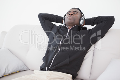 Casual man sitting on his sofa listening to music