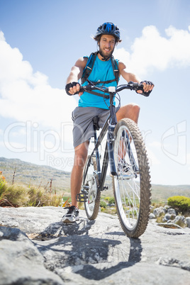 Fit man cycling on rocky terrain