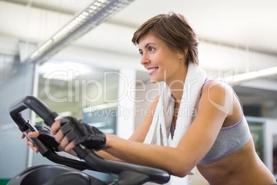 Fit smiling woman working out on the exercise bike