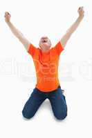 Mature man in orange tshirt cheering while kneeling
