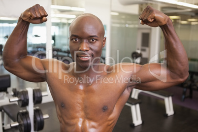 Shirtless muscular man flexing muscles in gym